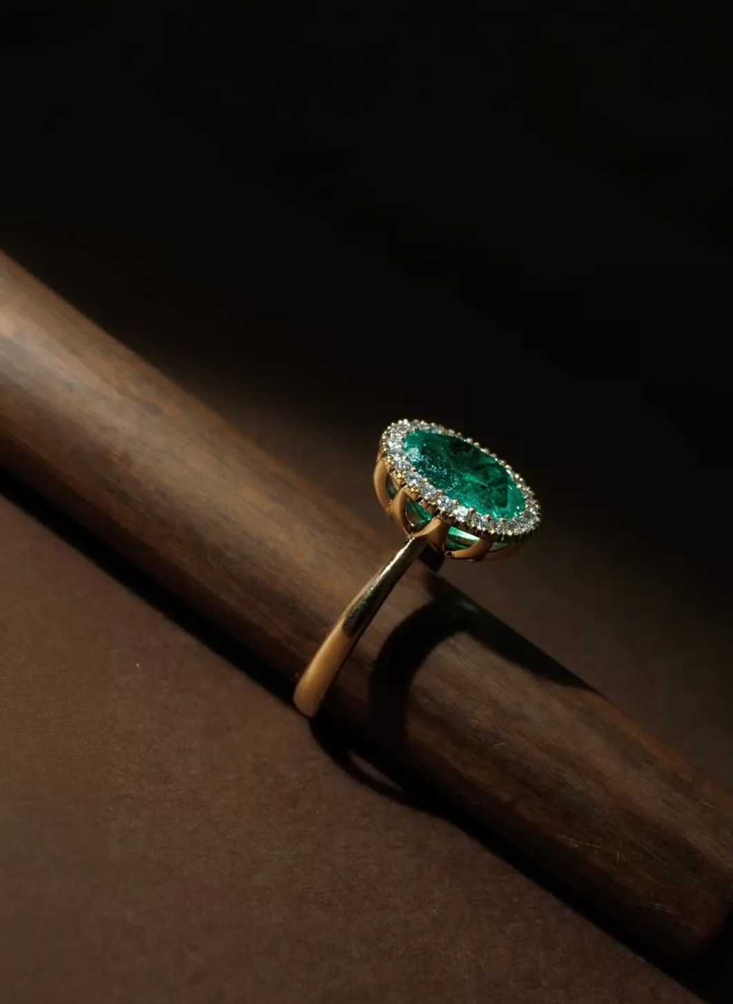 Emerald ring resting on a piece of wood